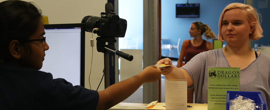 Student handing DragonCard to staff member