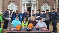Police Officer Sean McCallion poses with Drexel fraternity and sorority members at their Halloween community event