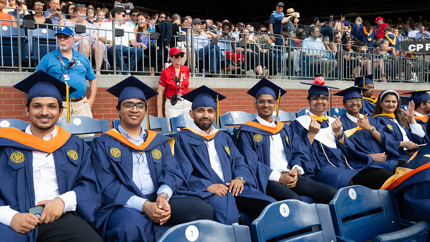 A row of men in graduation caps with one on the right with a cap with a Kirby wearing a graduation cap.