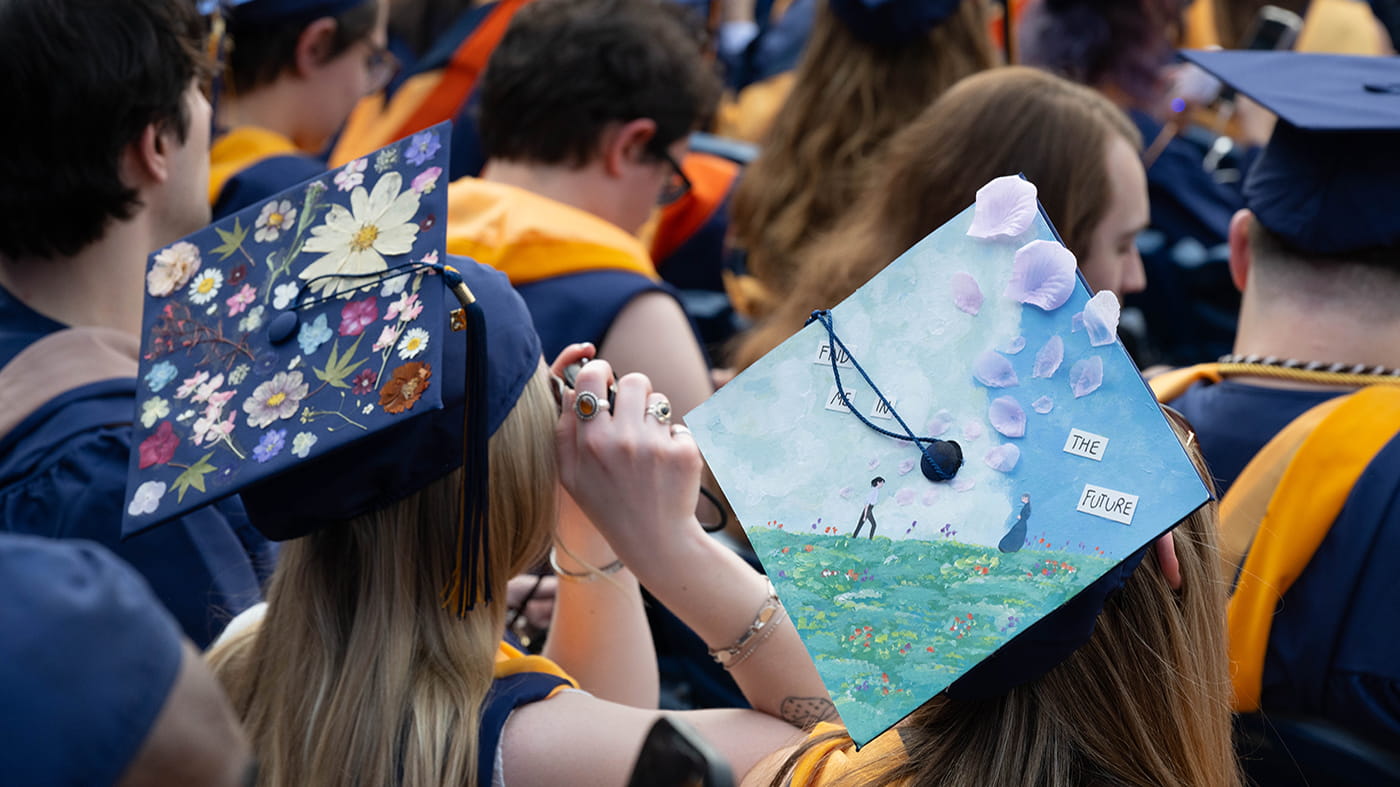 Two decorated caps, one with flowers and one with a floral garden landscape picture.